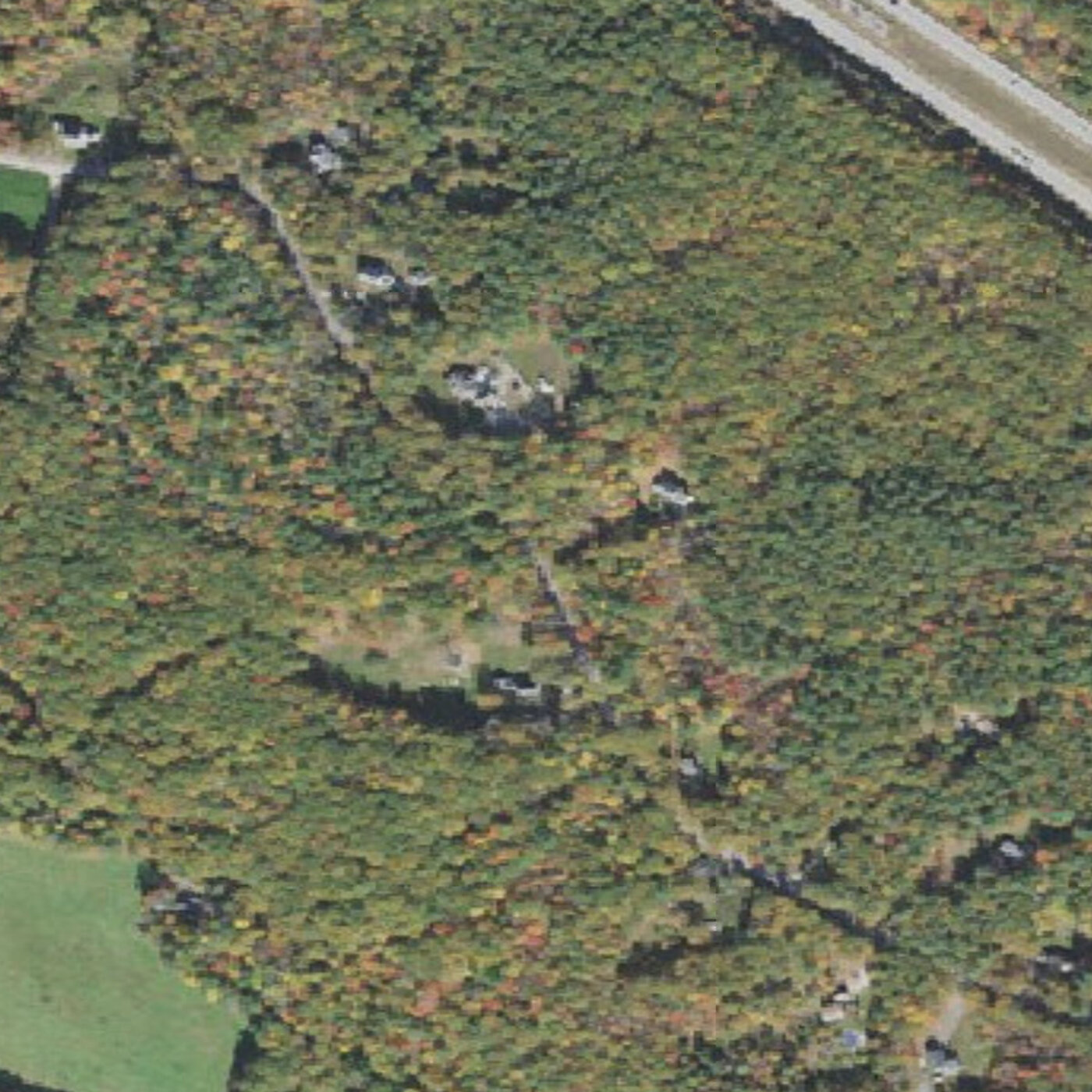 Aerial view of the wooded 12-acre property on Patten Hill in Candia, New Hampshire, in autumn